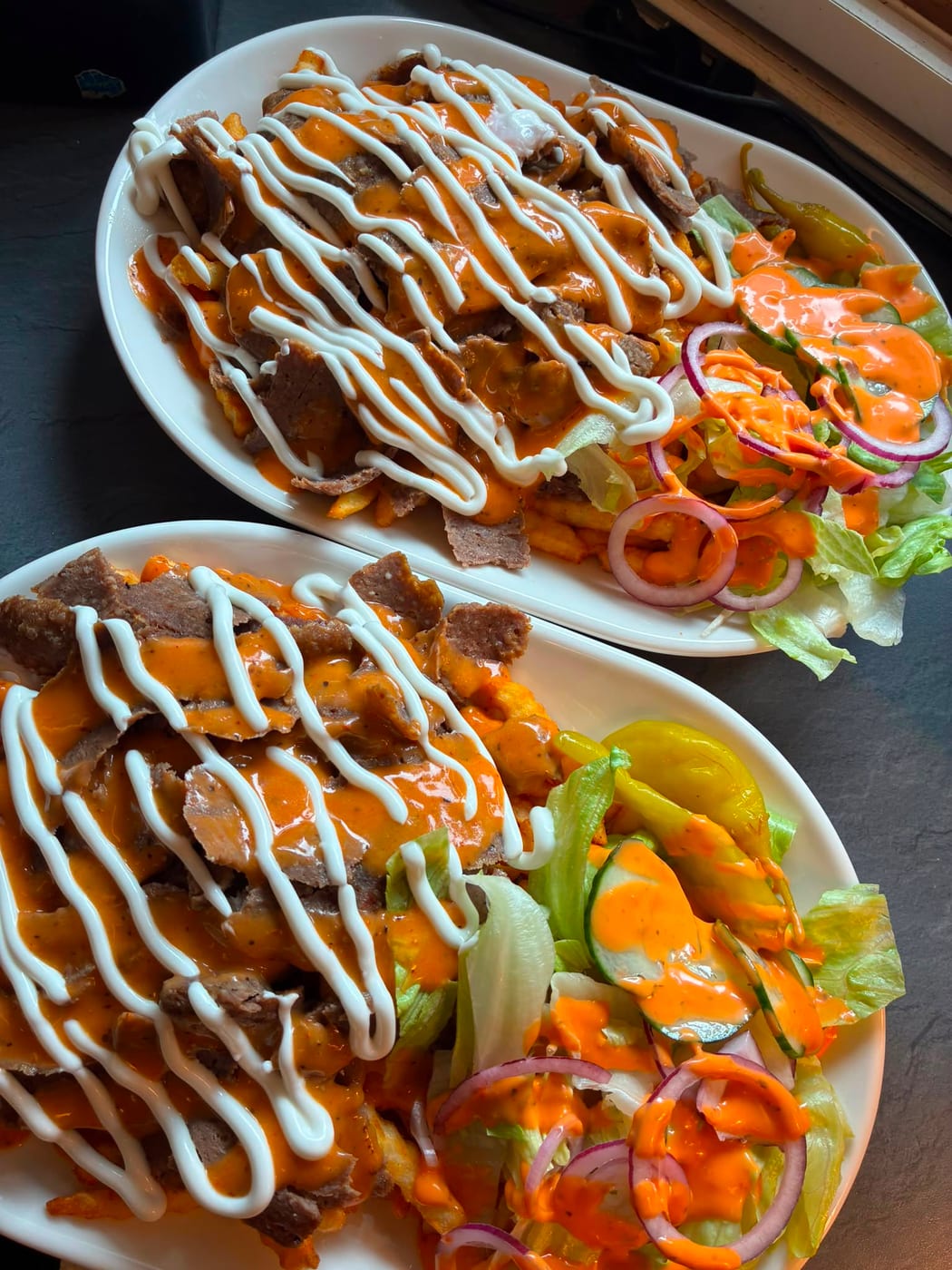 Kaksi kebab ranskalaisilla -annosta salaatin kanssa