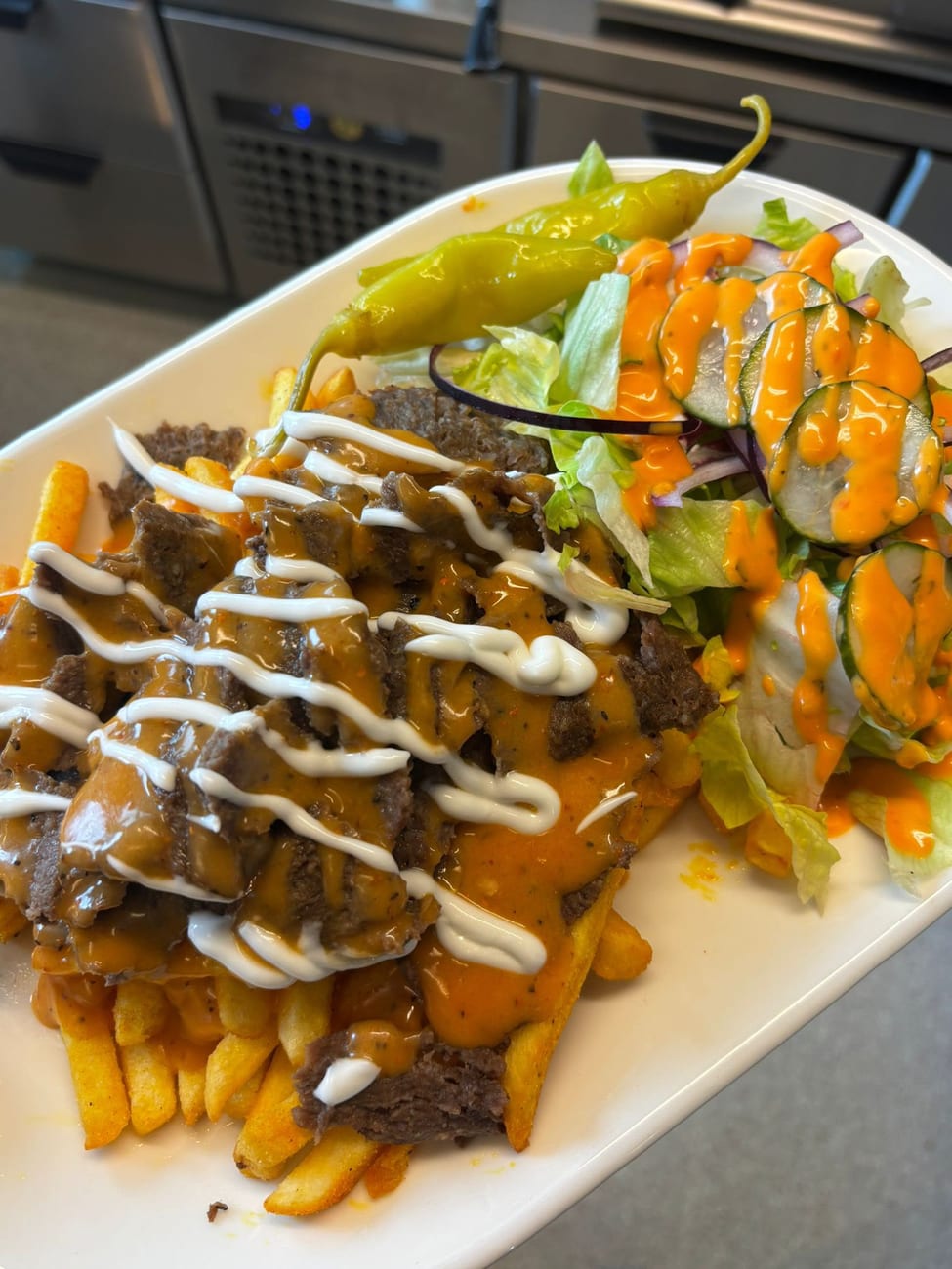 Kebab ranskalaisilla -annos: kebabia, ranskalaisia ja salaattia